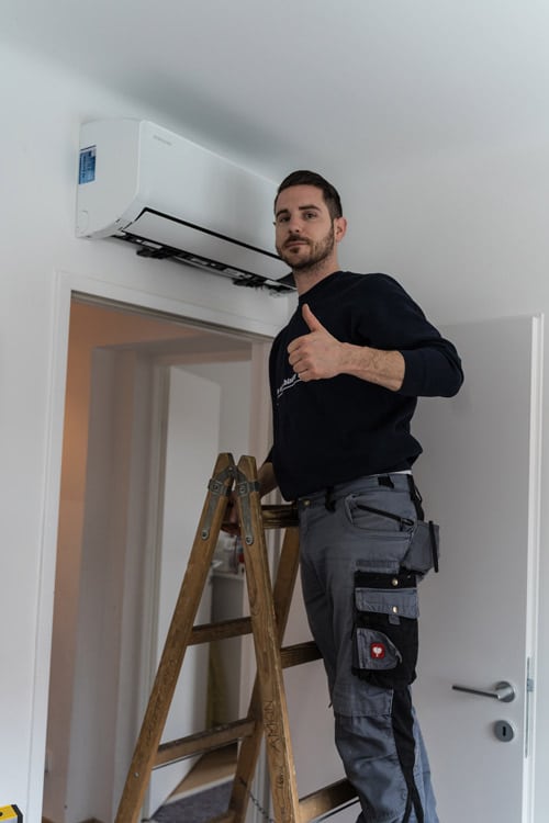 Monteur bei der Installation einer Klimaanlage – erfolgreicher Einbau eines Klimageräts.