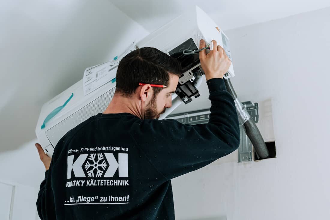 Techniker von Kratky Kältetechnik bei der Installation eines Klimaanlagengeräts an einer Wand